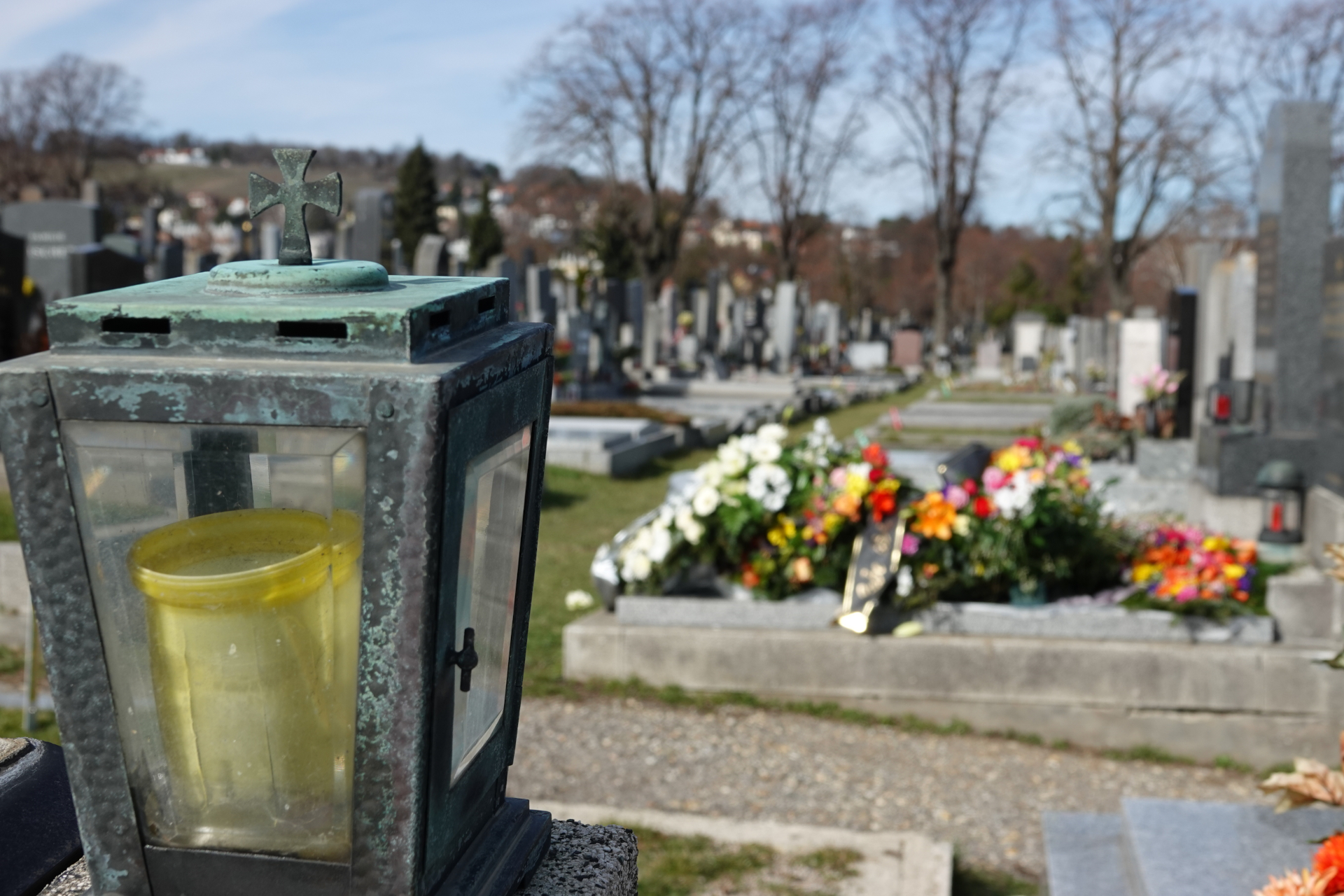 Grablampe mit gelbem Einsatz auf einem Friedhof.